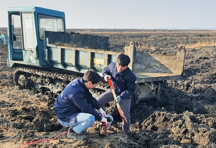 부석면 칠전리 B지구 민원현장에서 지난 10일 서산시청 공무원이 시료를 채취하고 있다