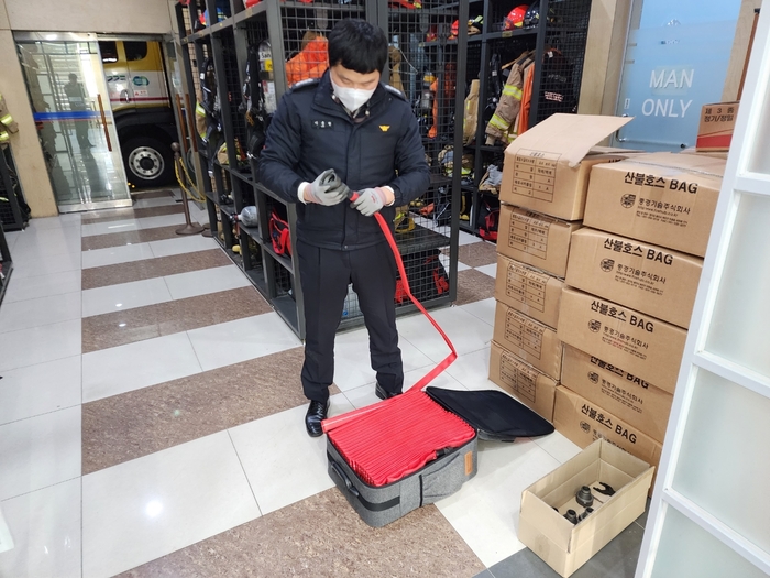 용인소방서 관계자가 산불호스백을 점검하고 있는 모습