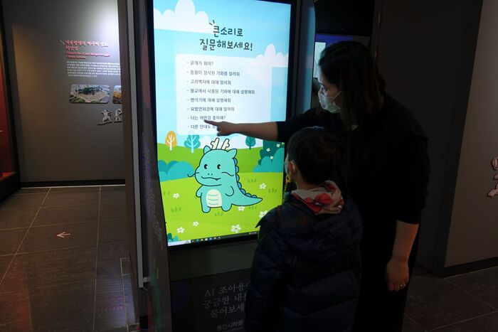 관람객들이 인공지능 기반 도슨트 키오스크를 체험하고 있다.