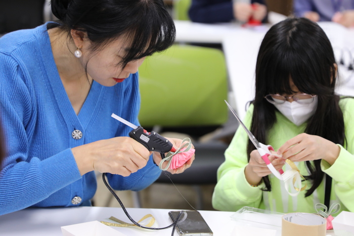 KB국민은행 정자동지역본부 강민주팀장이 자녀와 함께 소중한 카네이션을 한땀한땀 만들고 있다.