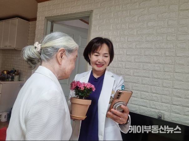 하남시에 거주하는 한 어르신이 하남시 방문간호사가 ‘마음속 새싹 가꾸기’ 프로그램 진행을 위해 전달한 꽃 화분을 바라보며 환하게 미소 짓고 있다.