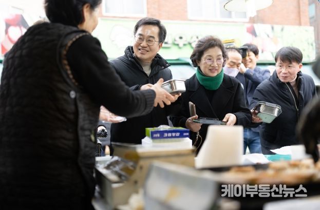 26일 오후 김동연 경기도지사와 정우영 배우자가 설맞이 의왕도깨비시장 방문하여 구매한 전을 다회용기에 포장하고 있다.