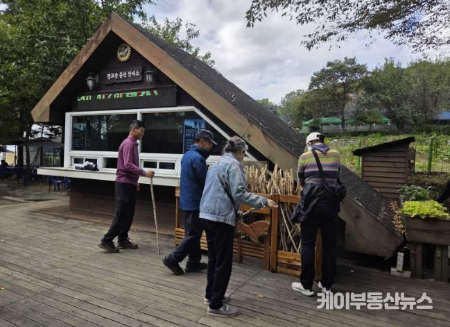 등산객들이 광교산 등산 안내소 앞에 있는 지팡이를 고르고 있다.